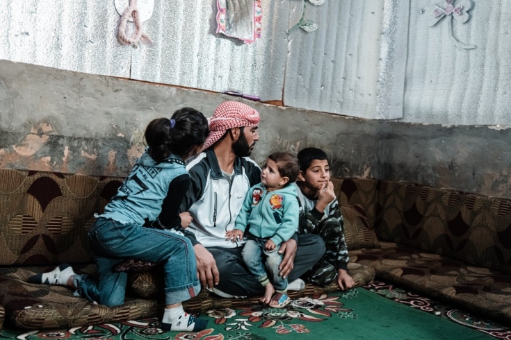 Ahmed y tres de sus hijos en su refugio construido por ellos mismos.