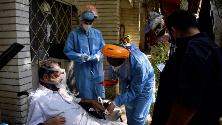 Médicos de MSF examinan a un paciente de COVID-19 en l unidad de cuidados respiratorios del hospital de Al-Kindi, Bagdad.