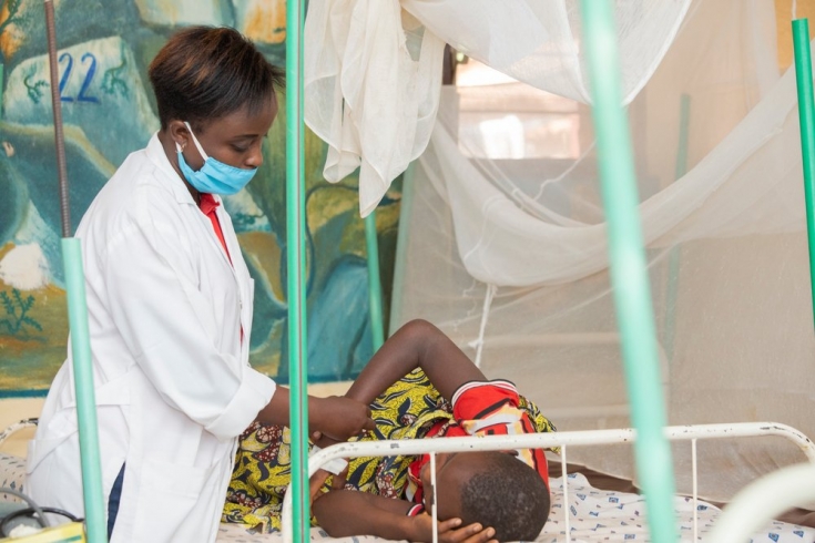 Una de nuestras compañeras revisa  la evolución de un paciente de malaria en el hospital del distrito de Kinyinya.
