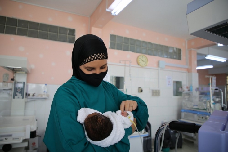 René Stone, nuestra enfermera supervisora, sostiene a un recién nacido en la unidad de cuidados especiales para bebés apoyada por MSF en el hospital de Al-Jamhouri de Taiz, Yemen.