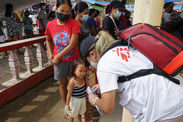 La doctora Chenery Ann Lim, coordinadora de la emergencia, habla con una madre y sus hijas en Barangay Catadman, Surigao City.