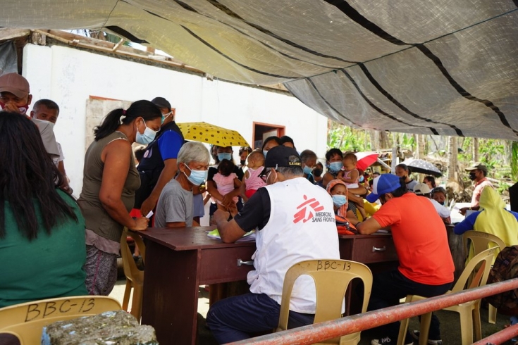Durante una distribución de kits de higiene, algunos lugareños hacen cola en la clínica móvil para consutar con el dr. Raul Salvador, nuestro jefe del equipo médico.