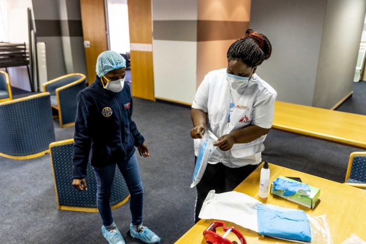 Bhelekazi Mdlalose, trabajadora de terreno de MSF que está trabajando como trazadora de contactos, da una formación sobre el uso de EPIs a  a una enfermera durante un chequeo masivo de COVID-19 en Johannesburgo, Sudáfrica.