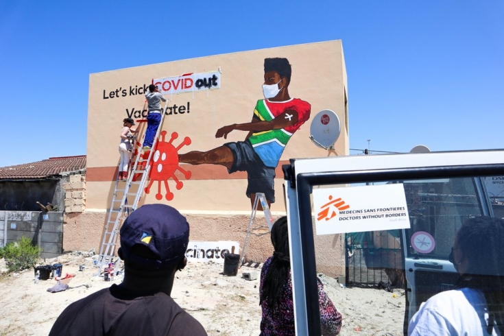 Últimos toques al grafiti pro-vacunación contra la COVID-19 en Khayelitsha.