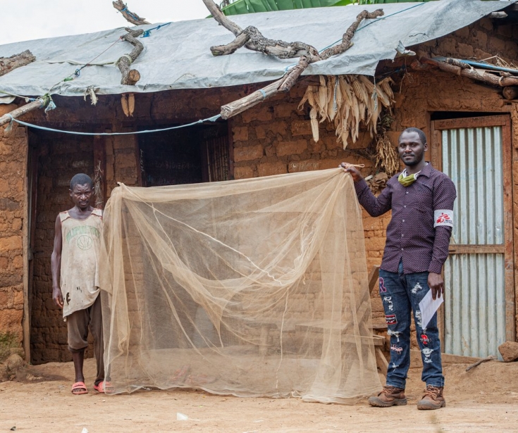 Sibomana, refugiado burundés, sostiene la mosquitera junto a Fulgence, nuestro supervisor de control del vector.