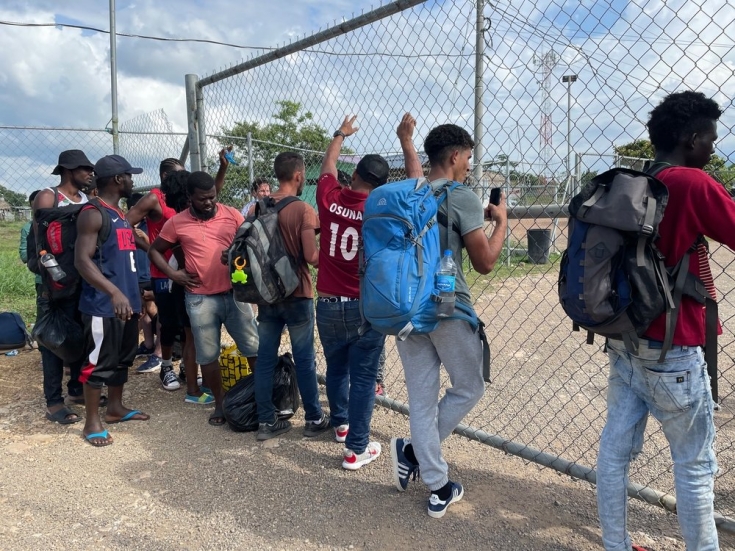 Un grupo de migrantes espera un autobús para dejar el centro de San Vicente, en Panamá.