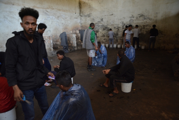 Personas efugiadas en el centro de detención de Dhar al-Jebel, en el almacén principal, donde estaban detenidos 700 de ellas.
