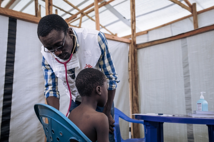 El doctor Padoue visita a un niño en la clínica móvil de MSF en el estadio de Rugabo, convertido en un asentamiento para personas desplazadas en Rutshuru. 