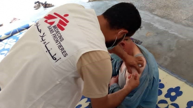 Trabajador de MSF vacuna a una persona desplazada en un campo en el noroeste de Siria.