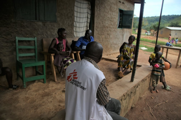 Gédéon, supervisor de promoción de la salud, habla con una familia en su casa en una zona rural en las afueras de Bangui, la capital de República Centroafricana, en septiembre de 2022. 