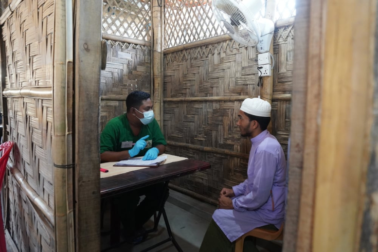 Md AJu habla con el asistente médico de MSF Robiul Awal. Ha venido a la clínica de Jamtoli en busca de un tratamiento para la sarna.